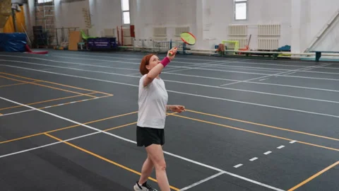 Female athlete practicing badminton with focus. Athletic woman practicing Stock Footage 341769269