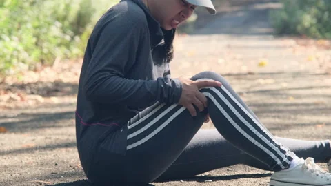 Female athlete sprained knee while training, holding her knee in pain. Stock Footage 172032685