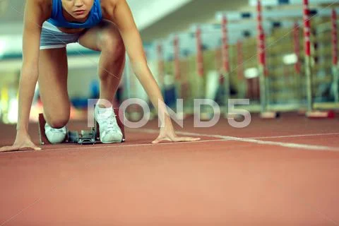 Female athlete at stadium starting to run Stock Photos