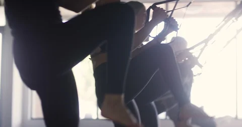 Female athletes using trx exercising in a gym Stock Footage 100185311
