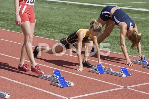 Female Athletes Warming Up At Starting Line Stock Photos