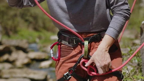 Female athletic Rock climber preparing to climb rocks. woman climber checking Stock Footage 273485378