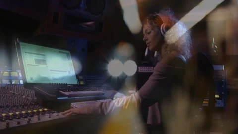 Female audio engineer adjusting console faders in studio, pressing play, Stock Footage 332566251