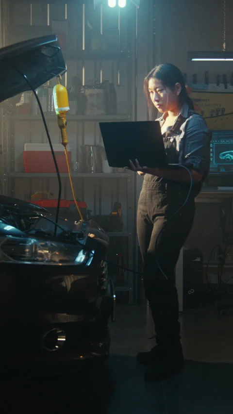 Female Auto Expert Conducting Computer Diagnostics on Car With Open Hood Vídeos de archivo 330264660