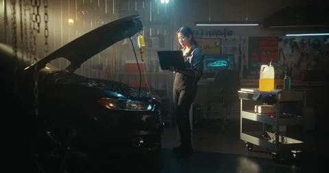 Female Auto Expert Conducting Computer Diagnostics on Car With an Open Hood Vídeos de archivo 330265504