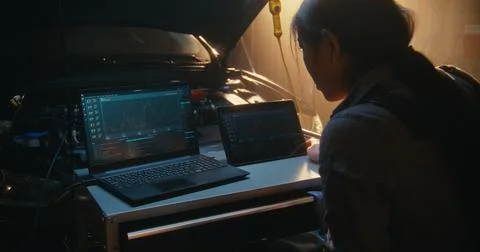Female Auto Expert Synchronizing Diagnostic Software Across Laptop and Tablet Stock Photos