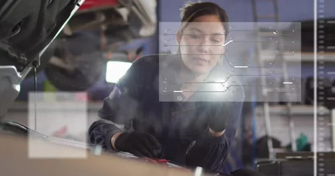 Female auto tech inspecting engine, holding light, HUD overlays layering over Stock Footage 330191252