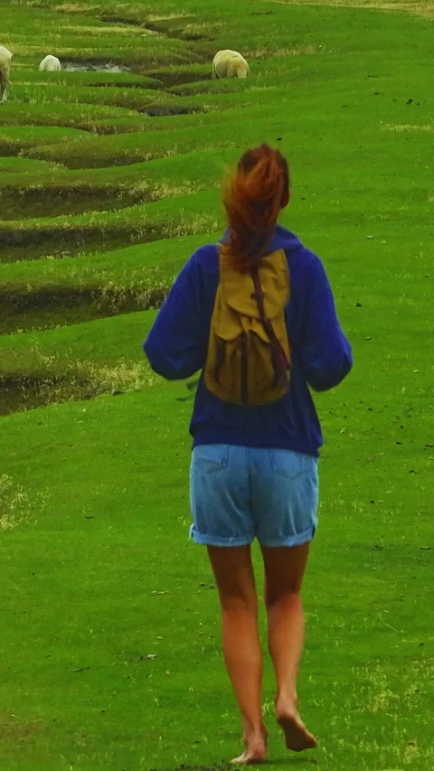 A female with a backpack visits the Mont Saint Michel castle while walking Stock Footage 302546949