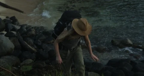 Female backpacker climbing on hill with view of tropical beach during sunrise Stock Footage 86107977