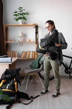 Female Backpacker packing backpack rucksack for her trip at home indoors Stock Photos
