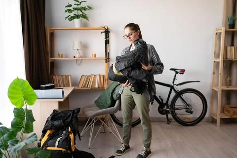 Female Backpacker packing backpack rucksack for her trip at home indoors Stock Photos