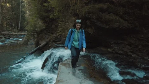 Female backpacker walking on rocks at stream. Girl traveler enjoying of outdoor Video stock 126422370