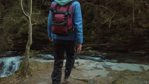 Female backpacker walking on rocks at the stream. Recreating of life and self is Stock Footage 126422971