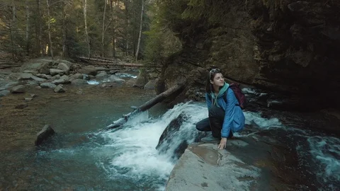 Female backpacker walking on rocks at the stream. Girl traveler enjoying of outd Video stock 126423686