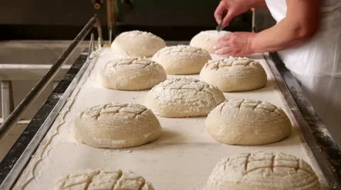 Female baker making traditional pattern on the raw ball dough bread. Bakehouse Stock Footage 64471075