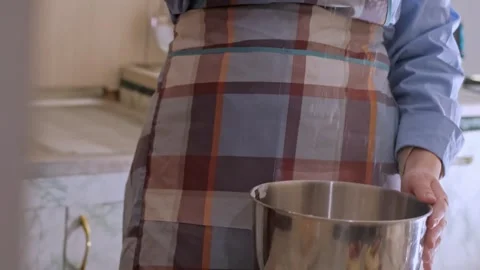 A female baker prepares cupcake batter, sprinkling flour on the table. Home-bake Видео 268247107