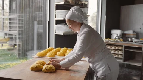 Female baker prepares raw bun before baking in oven Stock Footage 260337603