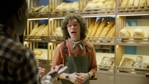 Female Bakery Worker Helping Customer to Choose Bread on Shelves 스톡 동영상 303454296