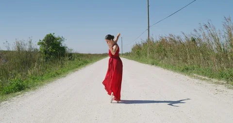 Female ballet dancer performing her routine on a country road Stock Footage 107648616