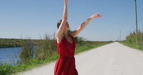 Female ballet dancer performing her routine on a country road Stock Footage 107650312
