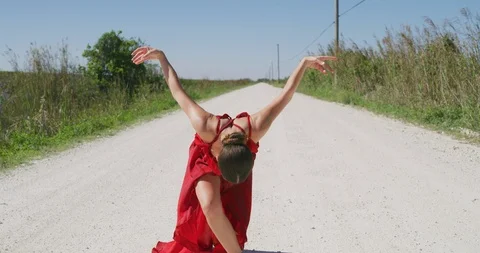Female ballet dancer performing her routine on a country road Stock Footage 107650723