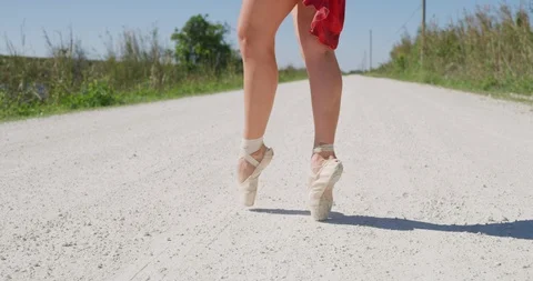 Female ballet dancer performing her routine on a country road Stock Footage 107655642