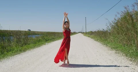 Female ballet dancer performing her routine on a country road Stock Footage 107660914