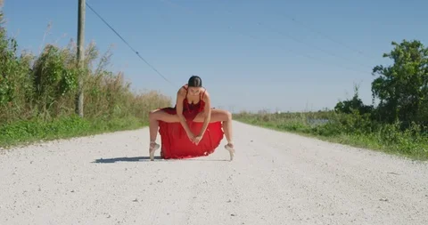 Female ballet dancer performing her routine on a country road Stock Footage 107667946