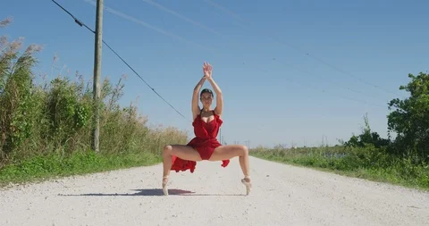 Female ballet dancer performing her routine on a country road Stock Footage 107669133