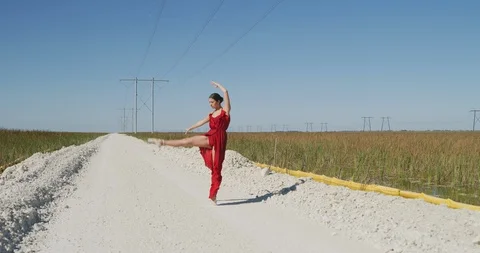 Female ballet dancer performing her routine on a country road Stock Footage 107674039