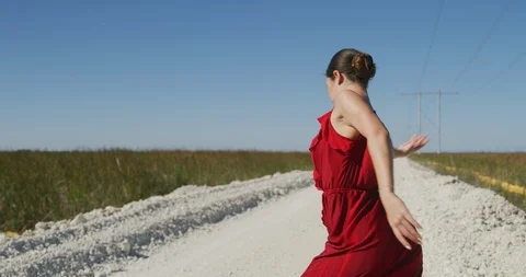 Female ballet dancer performing her routine on a country road Stock Footage 107674413