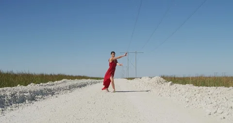 Female ballet dancer performing her routine on a country road Stock Footage 107675791
