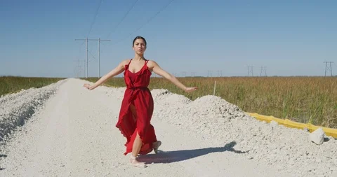 Female ballet dancer performing her routine on a country road Stock Footage 107677130