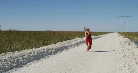 Female ballet dancer performing her routine on a country road Stock Footage 107680174