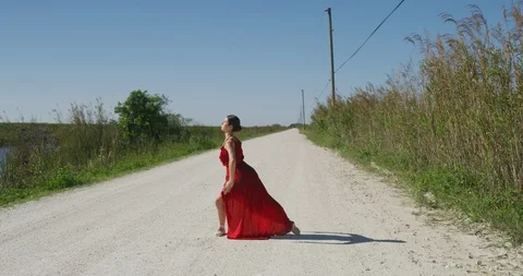 Female ballet dancer performing her routine on a country road Stock Footage 107684537