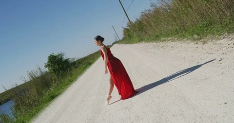 Female ballet dancer performing her routine on a country road Stock Footage 107687985