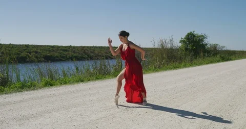 Female ballet dancer performing her routine on a country road Stock Footage 107688400