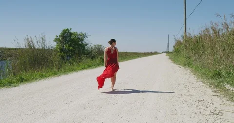 Female ballet dancer walking down country road Stock Footage 107659222