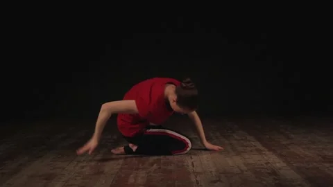 Female ballet dancer warming up in studio on black background 動画素材 104845148