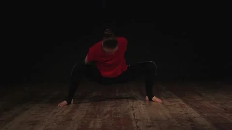 Female ballet dancer warming up in studio on black background 動画素材 104845153