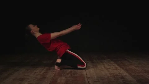 Female ballet dancer warming up in studio on black background  動画素材 104845204