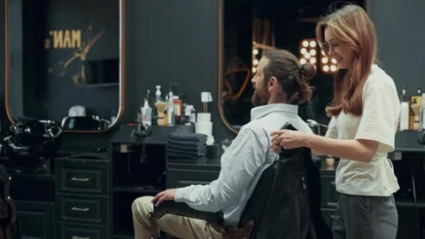 Female Barber Covering Client With Cape in Barbershop Video stock 342519306