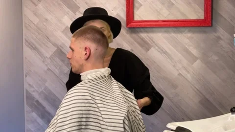 Female barber washes a young man's hair Stock Footage 337636721