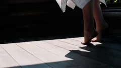 Woman swings bare feet lying on comforta, Stock Video