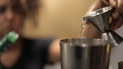 Female Barteder Using a Jigger to Make a Cocktail Stock Footage 128986837