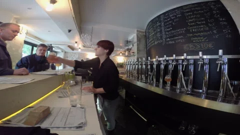 Female Bartender Serving Craft Beer at Modern Taproom Counter Stock Footage 346355441
