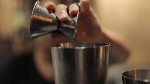 Female Bartender Using a Jigger to Make a Cocktail Stock Footage 128979919