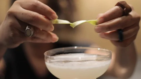 Female Bartender Using Lemon Zest in a Professional Cocktail Stock Footage 128986889