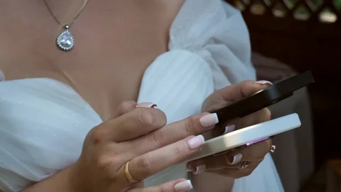 Female beautiful hands write a message on two phones at once. Stock Footage 247416614
