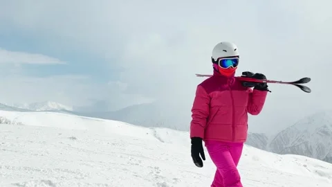 Female beginner skier in bright ski clothing holding carry skis overlooking.. Stock Footage 342930217
